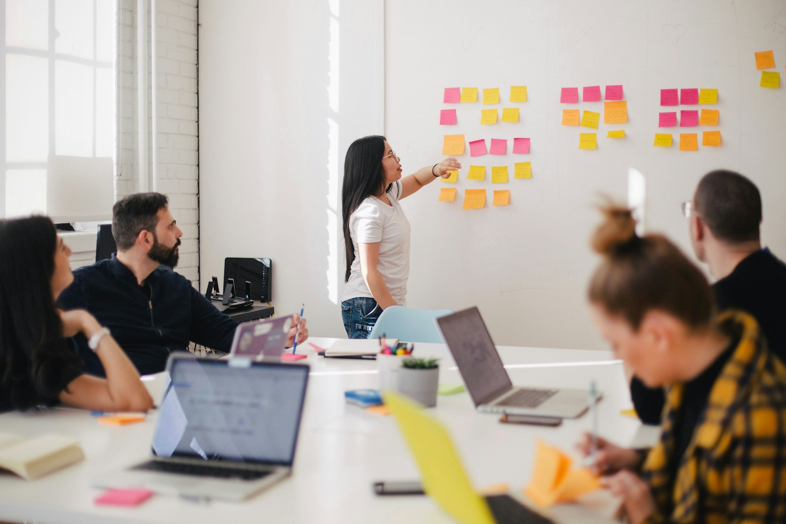 A facilitator walking a team through notes on a wall.